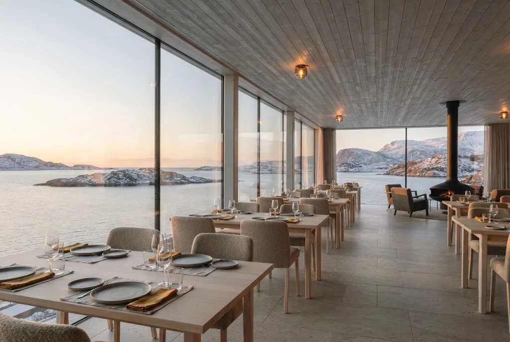 Artist's impression of the planned restaurant: a long pale-timber dining room along a glass wall facing the sea in the midnight light